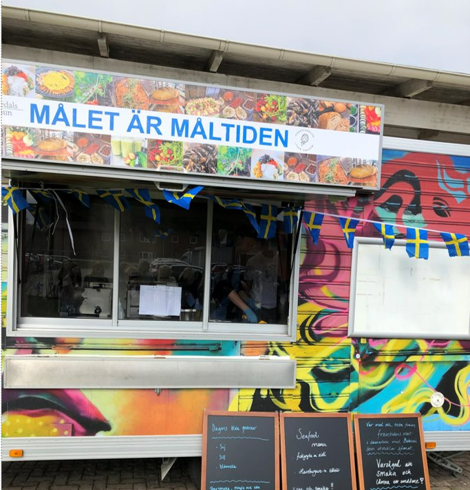 foodtruck med skyltar som beskriver maten som serveras.