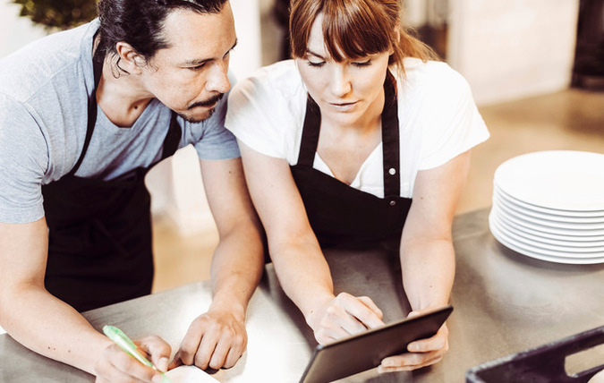 En kvinna och en man planerar i restaurangkök