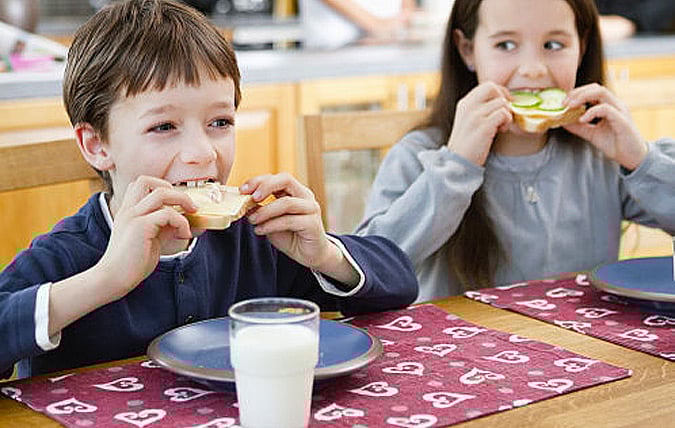 En tjej och en kille äter var sin macka