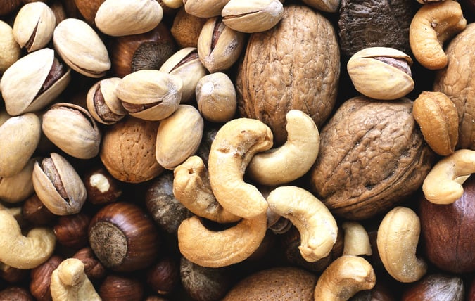 En närbild på massa olika nötter med och utan skal