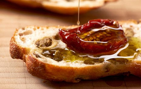 Soltorkad tomat med olja på en brödskiva. 